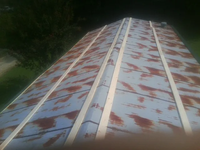 Rusted metal roof panels with new wood purlins before replacement — Storm Damage Roof Repair in Asbury by Roofing Brothers