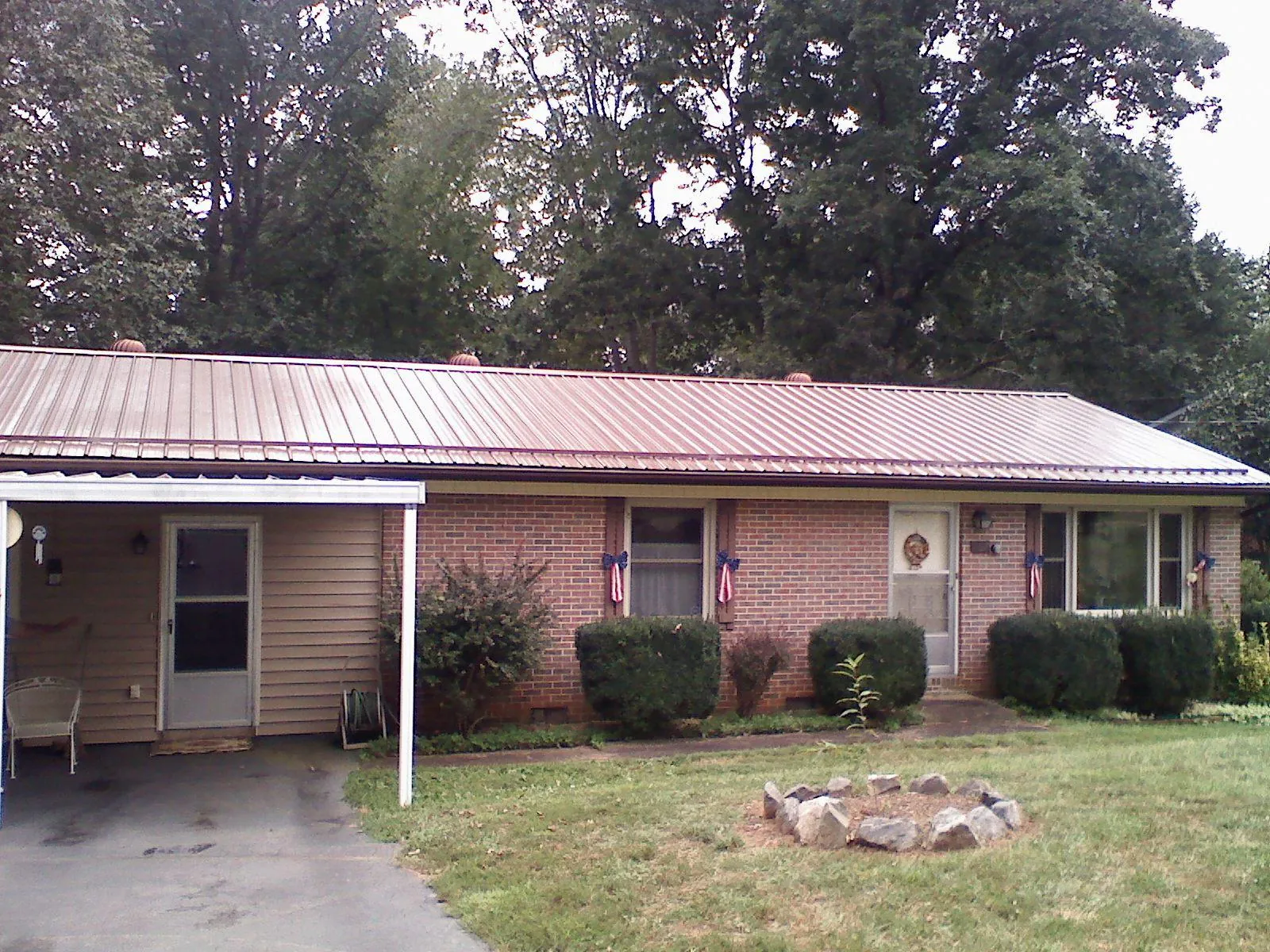 Bronze metal roof and carport on a brick ranch home — Roof Repair work by our crew in Asbury