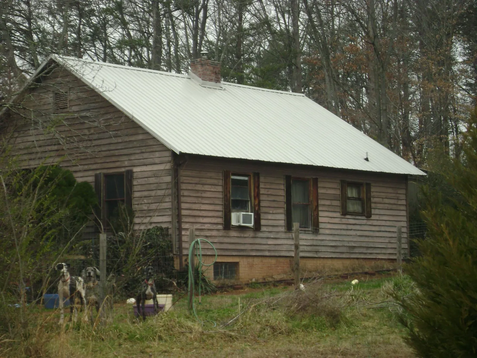 White metal roof on an old wood sided farmhouse, from a Metal Roof Installation job in Asbury